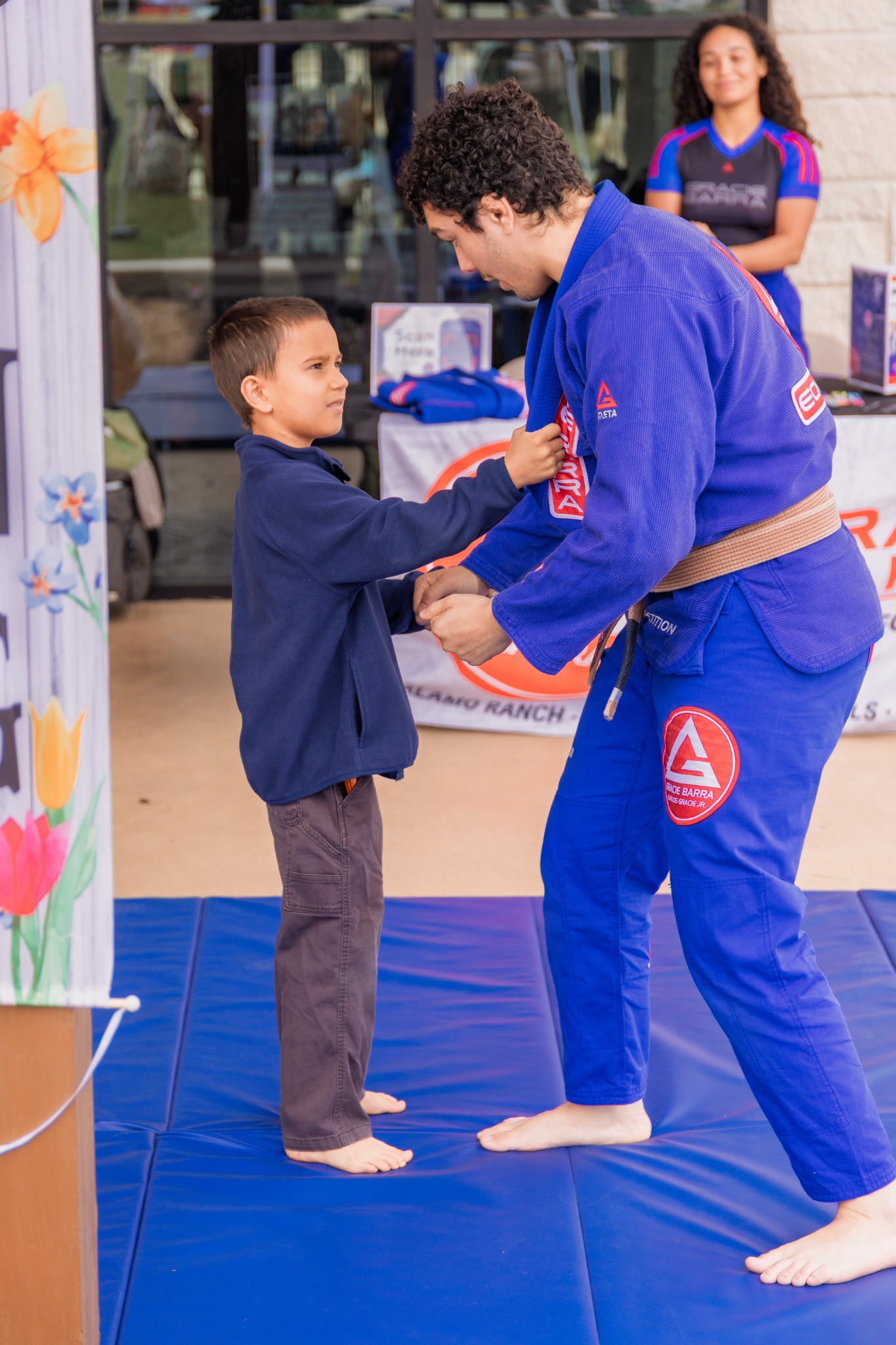Child participating in a martial arts activity at a vendor booth