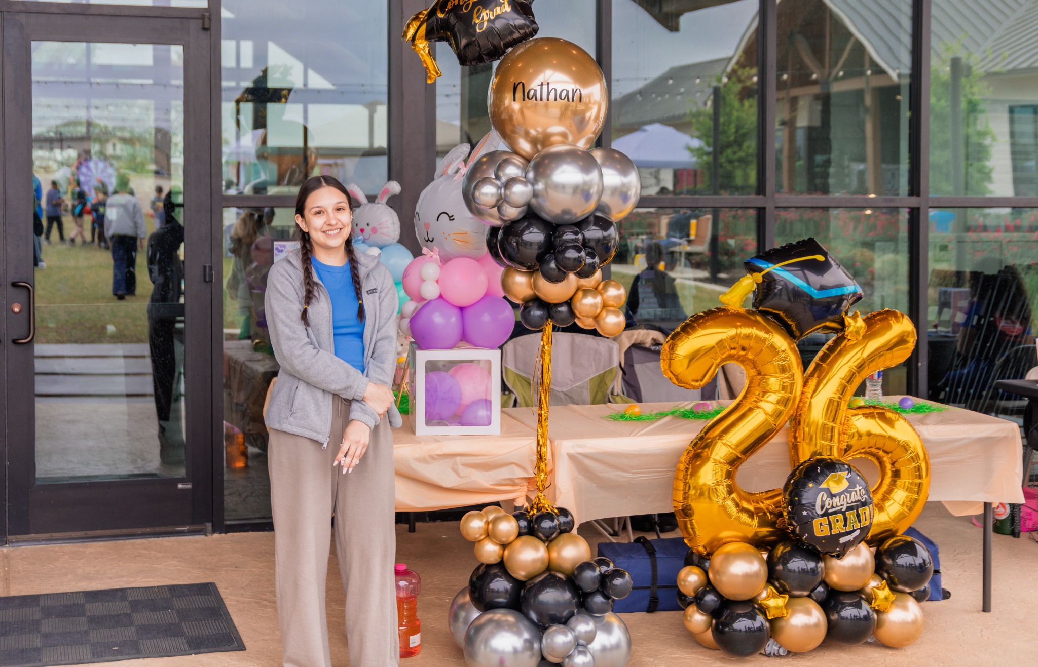 Vendor posing beside a festive balloon display