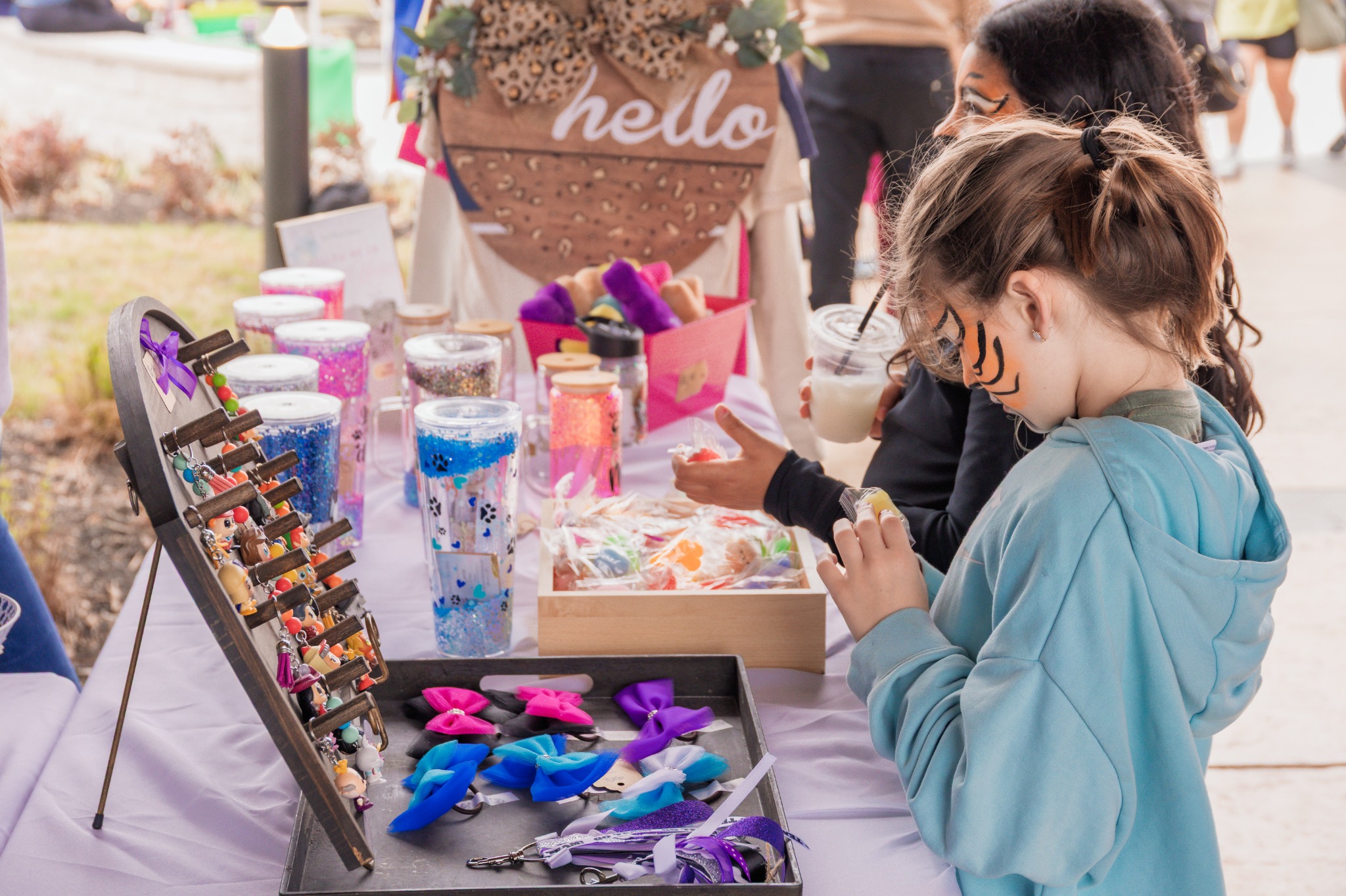 Young guest exploring colorful items at a vendor table