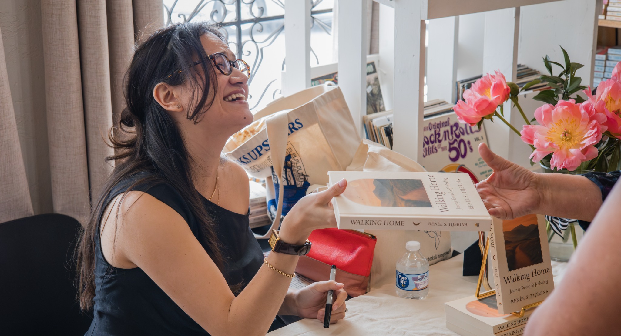 Renée S. Tijerina handing Walking Home to an attendee