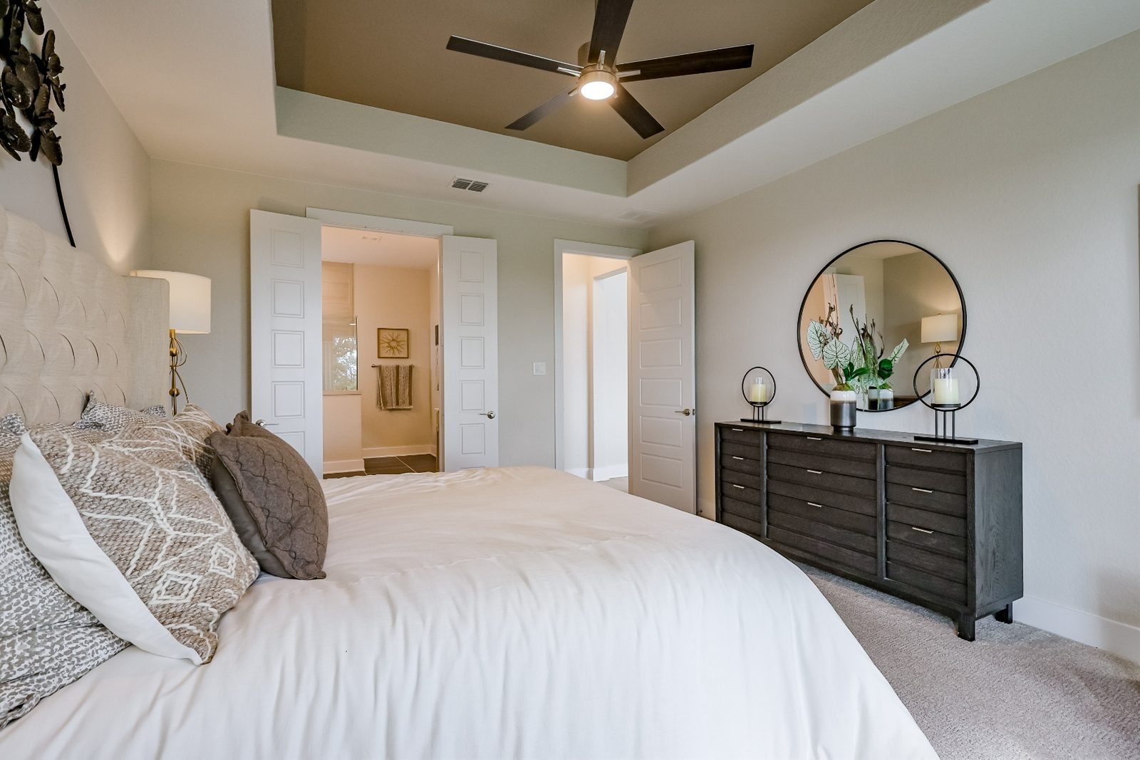 Primary bedroom with tray ceiling and upholstered headboard
